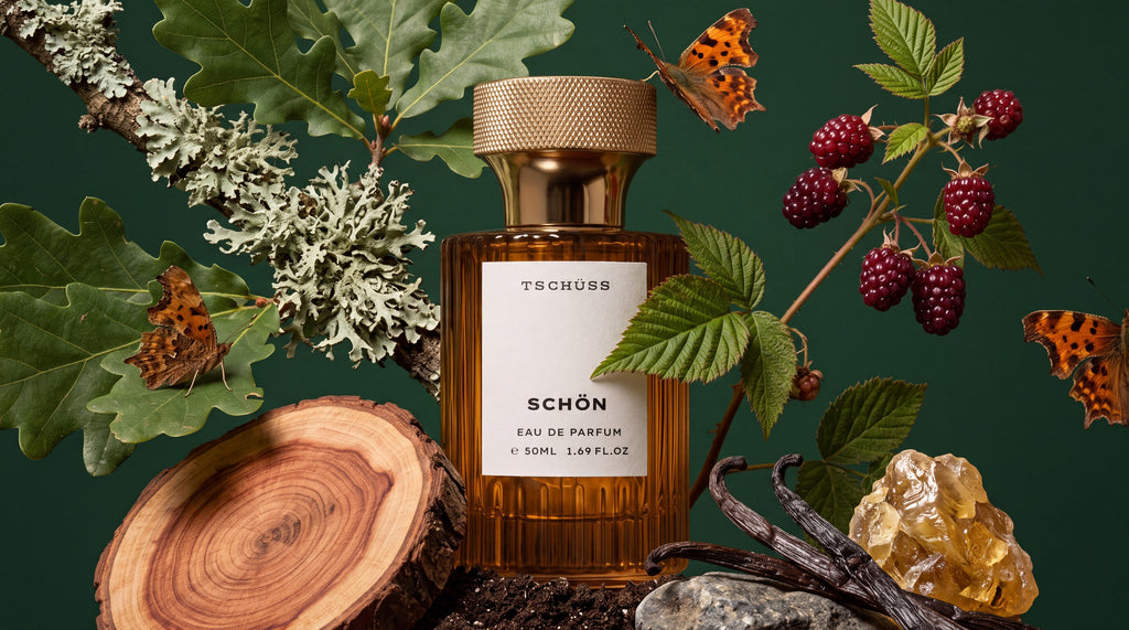 Schön eau de parfum bottle among blackberries, oak leaves, lichen and amber resin